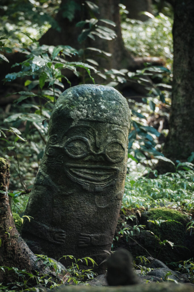 Tiki souriant de l'île de Hiva Oa, sculpture en pierre emblématique du patrimoine culturel des îles Marquises.